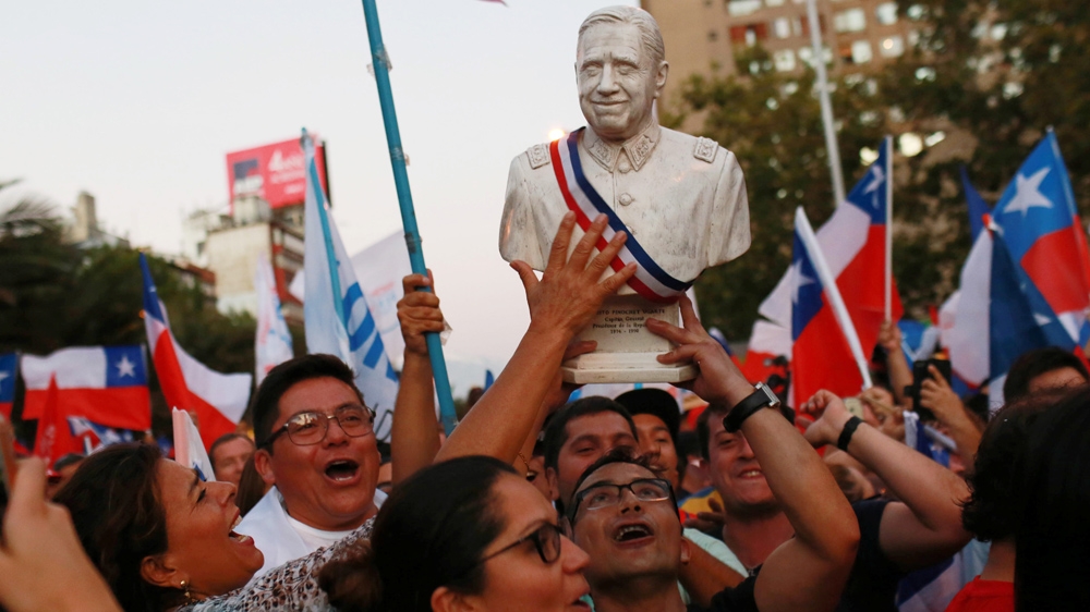 Supporters of Sebastian Pinera hold a bust of Pinochet aloft following the news of Pinera's election victory in December 2017 [Pablo Sanhueza/Reuters]