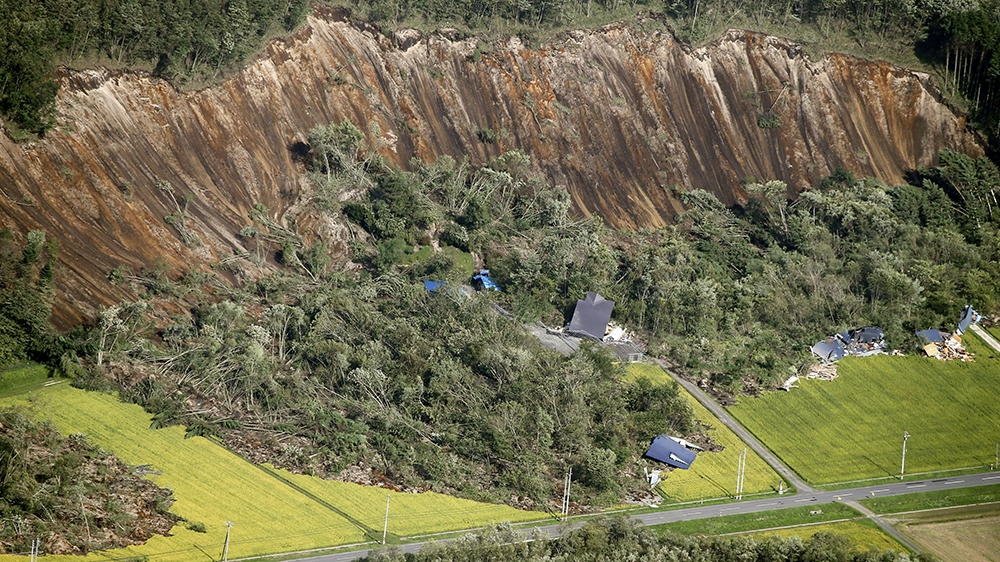 Houses damaged by the post-earthquake landslide are seen in Atsuma [Kyodo/via Reuters]