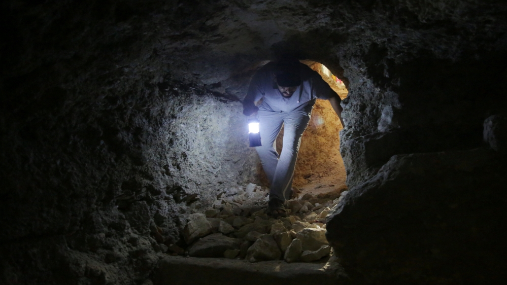 A makeshift shelter in an underground cave in Idlib [Khalil Ashawi/Reuters]