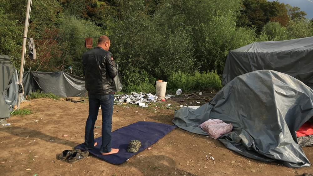 A Muslim man prays before attempting to leave the camp for Croatia [Mersiha Gadzo/Al Jazeera]