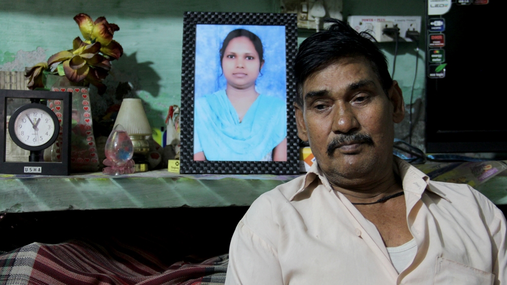 Tara Chand sits by a photograph of his late daughter Rajkumari [Nasir Kachroo/Al Jazeera]