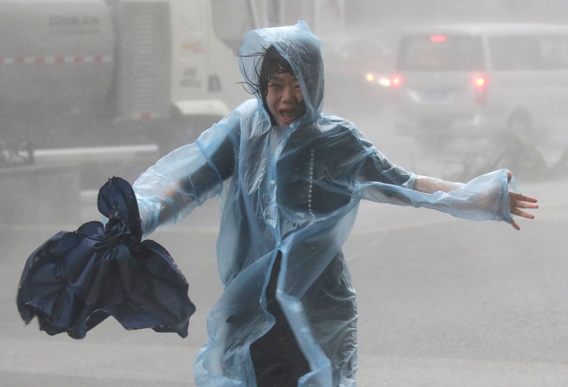 A woman runs in the rainstorm as Typhoon Mangkhut approaches, in Shenzhen, China September 16, 2018. REUTERS/Jason Lee