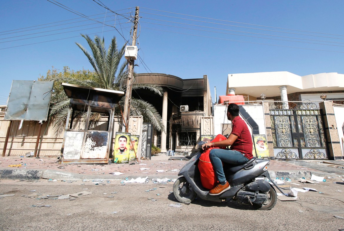 A man rides his motorcycle past the headquarters of MP Faleh al-Khazali, Secretary General of the Martyrs movement, which were set on fire by protesters in Basra, Iraq September 7, 2018. REUTERS/Essam