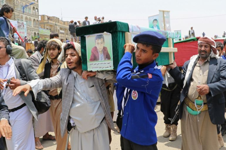 Mourners and a scout carry the coffin of a boy during the funeral of people killed in a Saudi-led coalition air strike on a bus in northern Yemen, in Saada