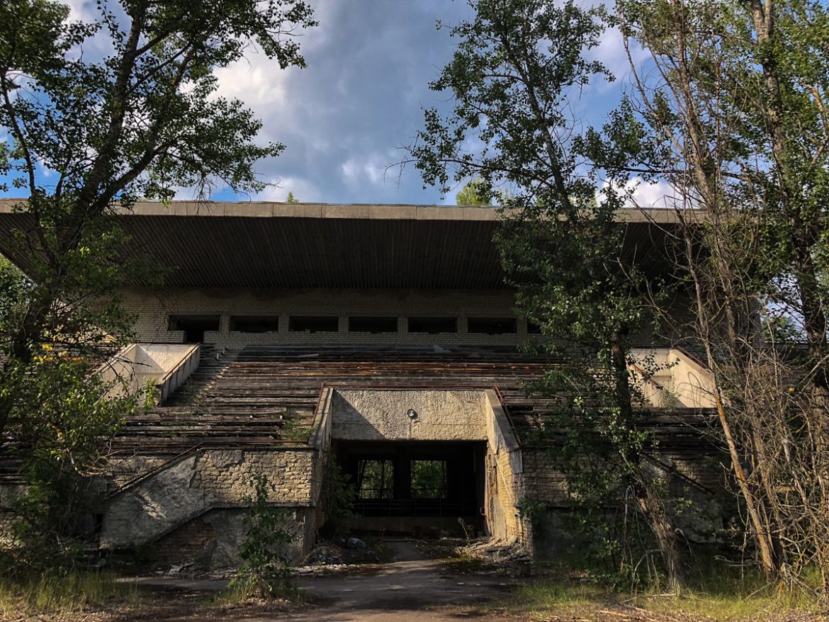 Radiation levels mean Pripyat will never again be inhabitable. But much of the city has been overtaken by the nearby forest, including its ruined sports stadium. [Blake Sifton/Al Jazeera]