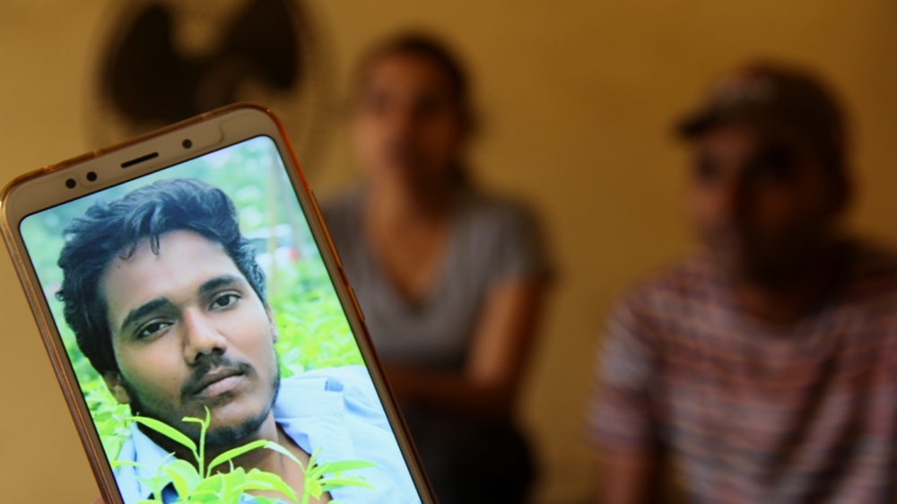 Vishal’s brother shows a photograph of his sibling on his mobile phone. Vishal died on September 9 while cleaning a septic tank in West Delhi [Nasir Kachroo/Al Jazeera]