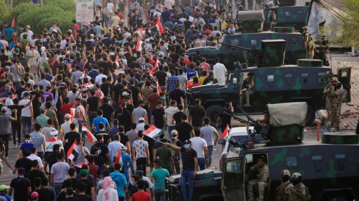 Iraqi protesters gather during a protest near the building of the government office in Basra