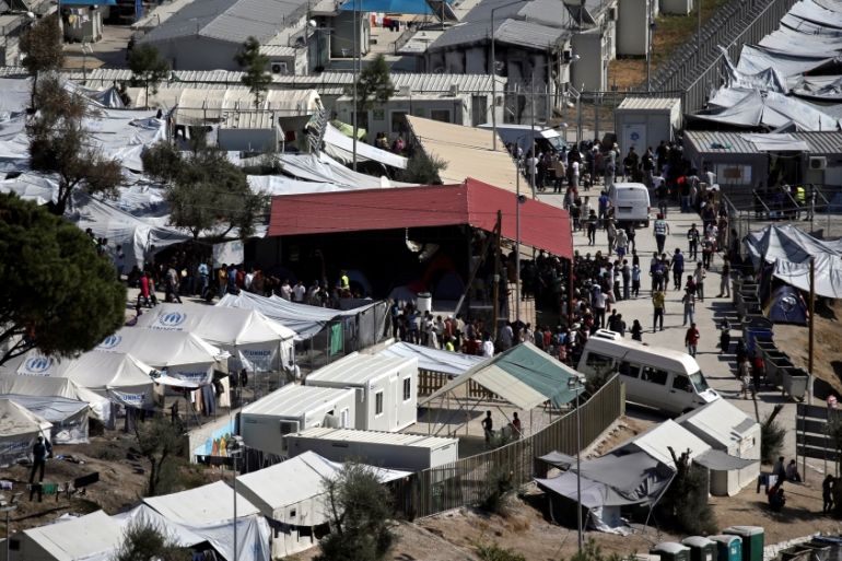 FILE PHOTO: Refugees and migrants line up for food distribution at the Moria migrant camp on the island of Lesbos