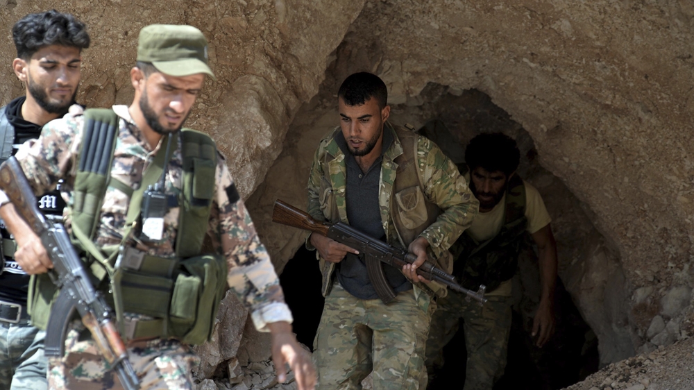 Free Syrian Army fighters exit a cave in the outskirts of Jisr al-Shaghur in Idlib province [Ugur Can/DHA via AP) 