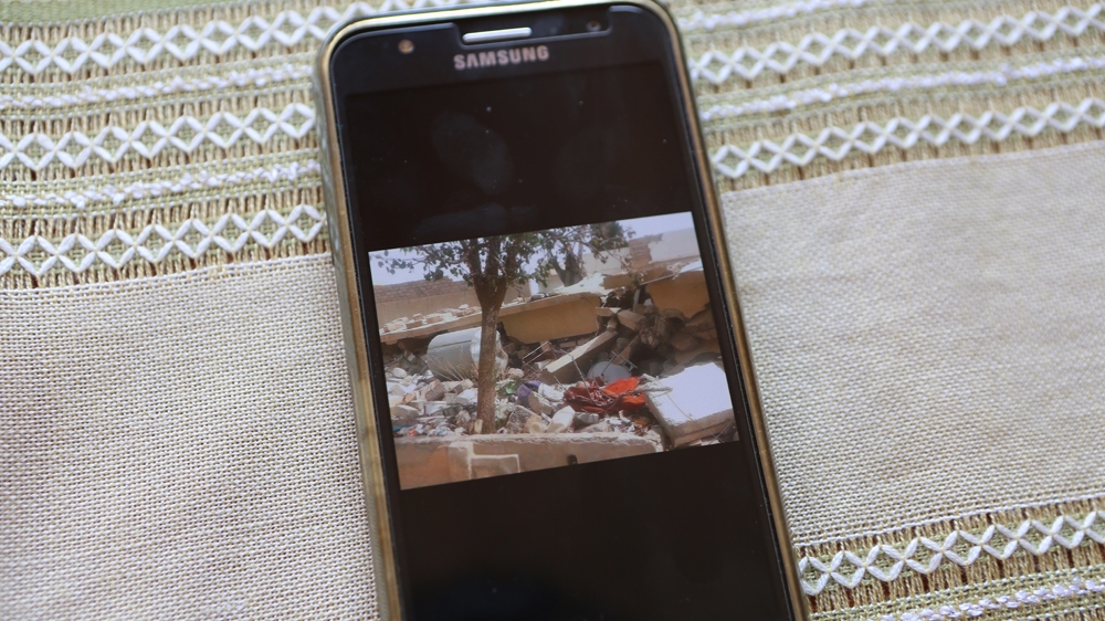 Shams' and Hassan's house, shown in a photo on a mobile phone, that was destroyed in Deir Az Zor [Mersiha Gadzo/Al Jazeera]