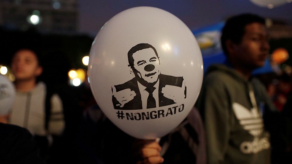 A demonstrator holds a balloon with an image depicting Guatemala's President Jimmy Morales as a clown during a protest against his decision to not renew the mandate of CICIG [File: Luis Echeverria/Reuters] 