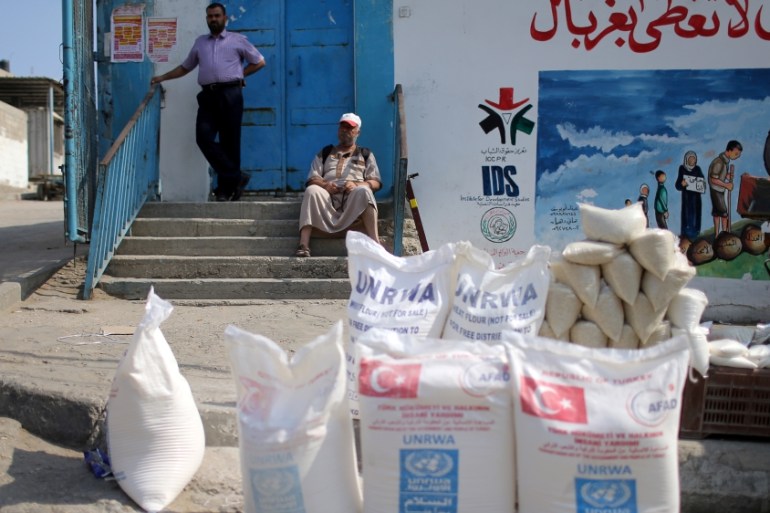 Palestinian man sits outside an aid distribution center run by UNRWA in Khan Younis