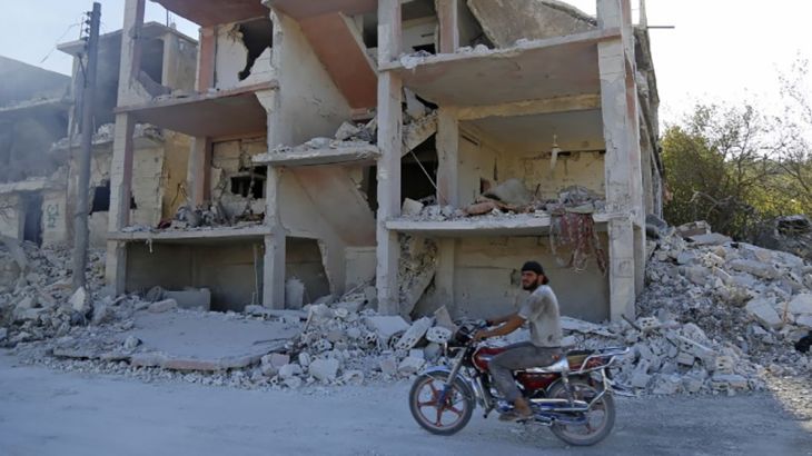 A Syrian man rides a motorcycle past a destroyed building in an area that was hit by a reported air strike in the district of Jisr al-Shughur, in the Idlib province, on September 4, 2018. Russian warp