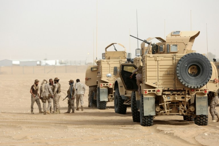 Saudi troops gather at an airfield where Saudi cargo planes delivered aid in the northern province of Marib