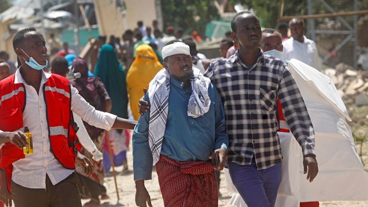 Somali medical personnel help a civilian who was wounded in a blast outside the compound of a district headquarters in the capital Mogadishu, Somalia Sunday, Sept. 2, 2018. A Somali police officer say