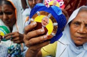 Women show rakhis or sacred threads with a picture of Indian Prime Minister Narendra Modi at a temple in Vrindavan in the Indian state of Uttar Pradesh on August 17, 2016 [Jitendra Prakash/Reuters]