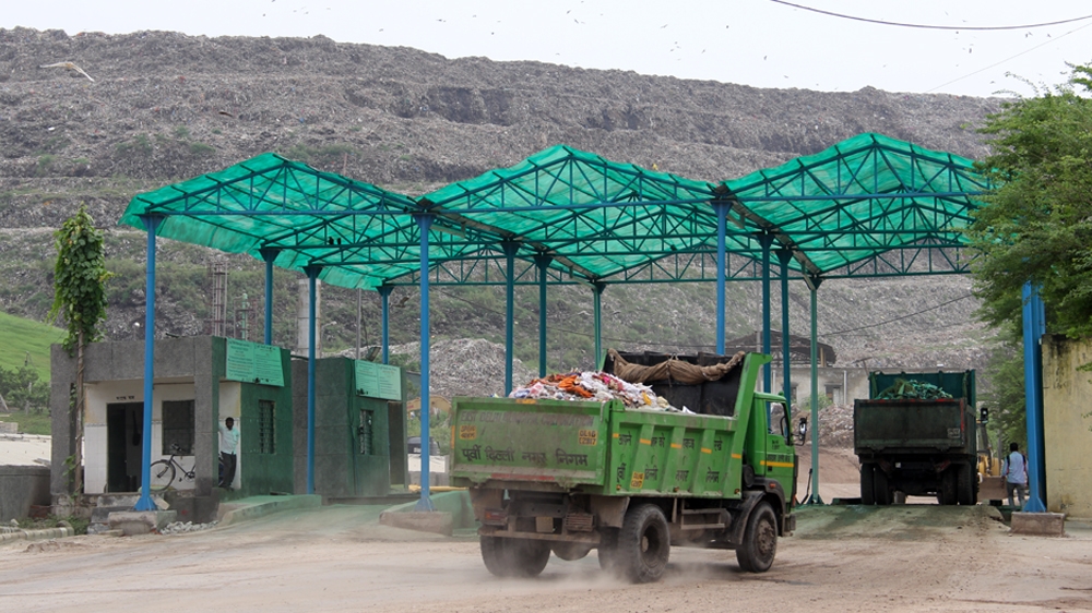 Trucks enter the Ghazipur landfill site. On average, Delhi produces 9,500 tonnes of rubbish a day [Nasir Kachroo/Al Jazeera]
