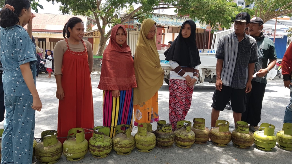 Women line up to buy rationed cooking gas in Palu. [Ted Regencia/Al Jazeera]