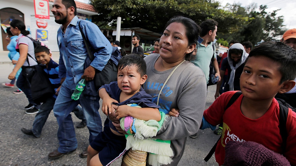 Honduran migrants react after crossing the border between Honduras and Guatemala, in Agua Caliente, Guatemala [Jorge Cabrera/Reuters] 