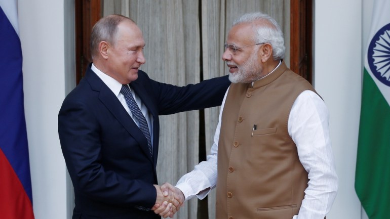 Russian President Vladimir Putin and India's Prime Minister Narendra Modi shake hands.