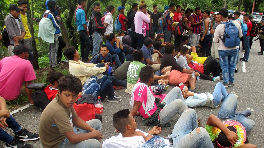 
Dozens of Hondurans rest at the side of the highway north of Esquipulas while waiting for directions from Guatemalan police special forces halting their advance [Sandra Cuffe/Al Jazeera] 
