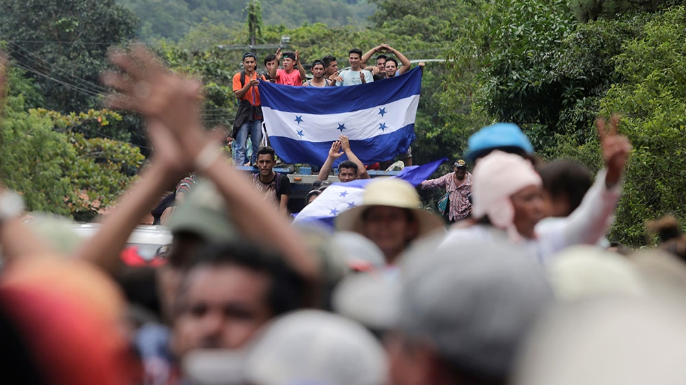 Honduran migrants, part of a caravan trying to reach the US, arrive at the border between Honduras and Guatemala [Jorge Cabrera/Reuters]