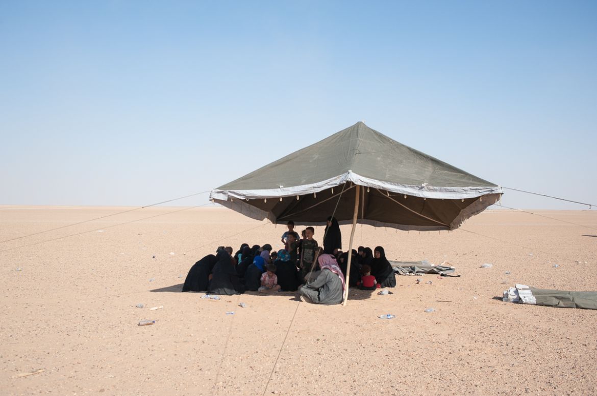 Under a tent in the desert IDPs from Hajin wait to be identified by SDF intelligence security to enter the temporary camp of Hajin. September 2018