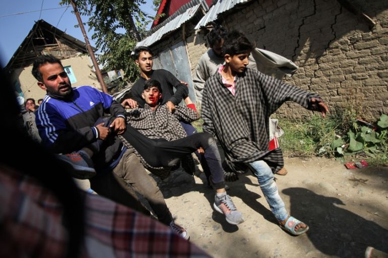 Locals carrying an injured from the gun-battle site [Sameer Mushtaq/Al Jazeera]