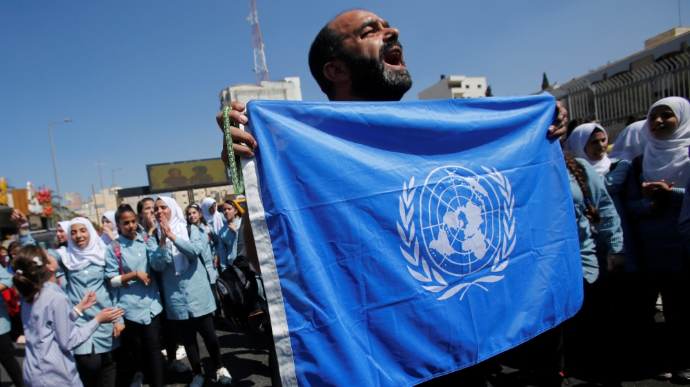 Palestinian demonstrator holds UN flag during a rally against a U.S. decision to cut funding to UNRWA and in support of president Mahmoud Abbas, in Bethlehem in the occupied West Bank