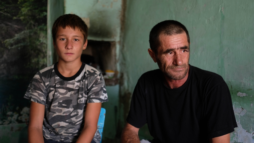 Zapir Amaradziev and his son. Amaradziev says his wife left because she was exhausted with the challenges fishing brought to the family [Nikolay Korzhov/Al Jazeera]