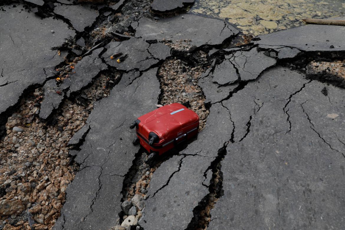 A luggage as seen on a broken road after an earthquake hit Balaroa sub-district in Palu, Indonesia, October 4, 2018. REUTERS/Beawiharta