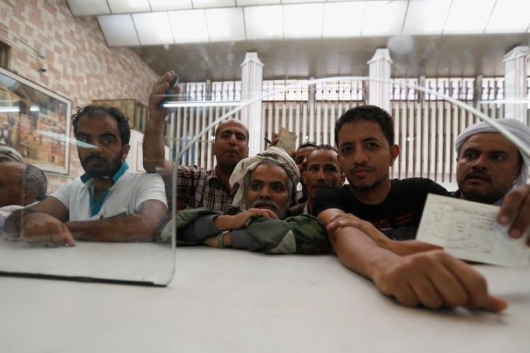 People wait for cash at the Central Bank of Yemen in Sanaa