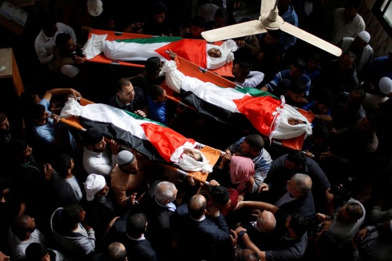 Mourners carry the bodies of Palestinian boys who were killed in an Israeli air strike on the Gaza Strip frontier, during their funeral in the central Gaza Strip