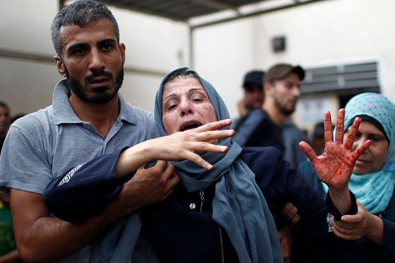 The mother of a Palestinian, who was killed an Israeli air strike, reacts as her hand is stained with his blood at a hospital in the northern Gaza Strip October 17, 2018. REUTERS/Mohammed Salem