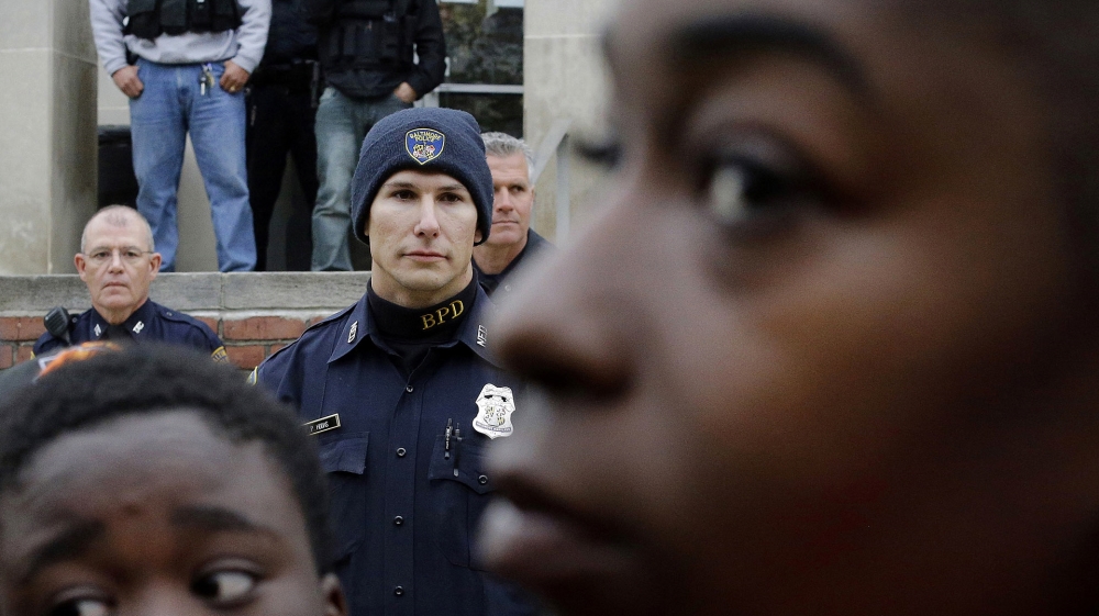 Members of the Baltimore Police Department stand guard outside the department's Western District police station during a protest in response to Freddie Gray's death in Baltimore [AP Photo/Patrick Semansky/File]