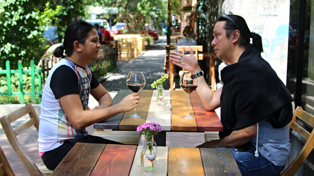 Edward Rigor and a friend enjoy a glass of wine in Yerevan, Armenia. He is one of more than 22,000 Filipinos to visit Armenia each year [Megan Iacobini de Fazio/Al Jazeera]