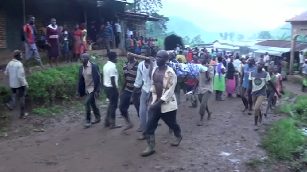 Residents carry dead bodies after the landslide hit Bududa in Uganda [Reuters TV/via/Reuters]