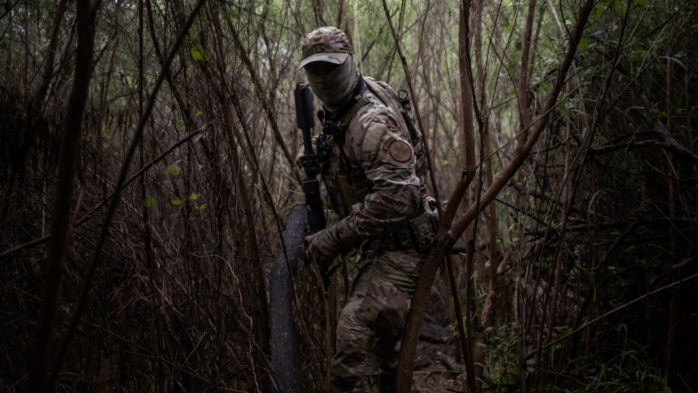 An agent with the U.S. Border Patrol Tactical Unit (BORTAC) searches a pathway near the Rio Grande river used by families who illegally cross into the United States from Mexico in Fronton, Texas