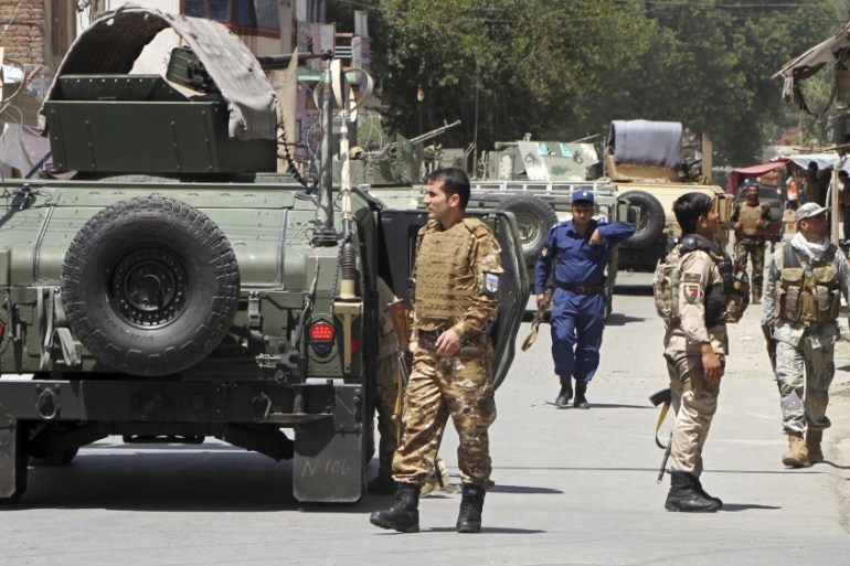 Security forces gather following a deadly attack including a suspected suicide car bombing and gunbattles, in Jalalabad, Afghanistan, Tuesday, July 31, 2018. An Afghan provincial official said a coord