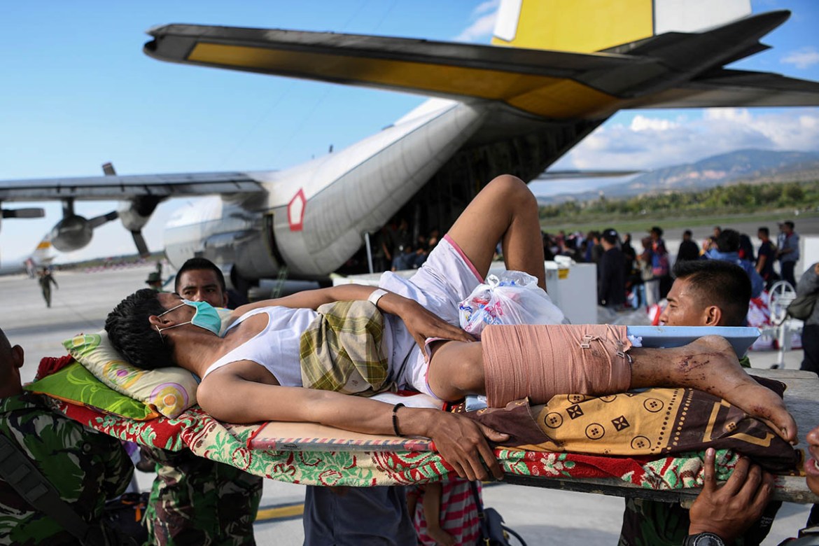 An injured man is evacuated on a military aircraft following an earthquake and tsunami at Mutiara Sis Al Jufri Airport in Palu, Central Sulawesi, Indonesia September 30, 2018 in this photo taken by An