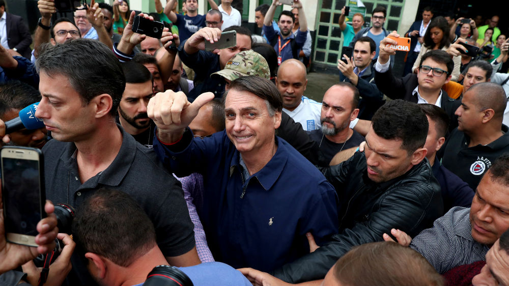 Jair Bolsonaro gestures after casting his vote, in Rio de Janeiro [Pilar Olivares/Reuters]