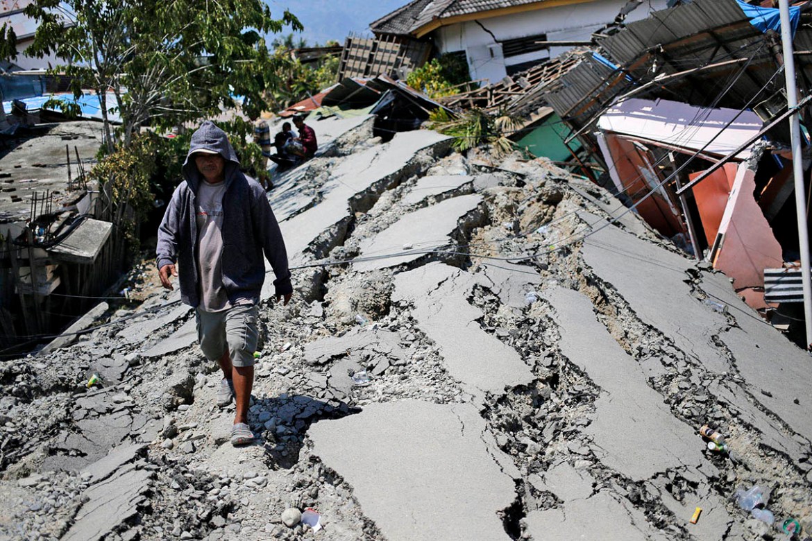 A man walks on a heavily damaged street due to the earthquake in Balaroa neighborhood in Palu, Central Sulawesi, Indonesia Indonesia, Tuesday, Oct. 2, 2018. Desperation was visible everywhere Tuesday