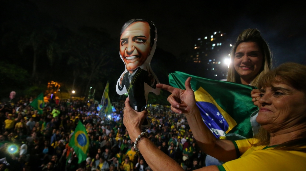 Supporters of Jair Bolsonaro react after he wins the presidential race [File: Amanda Perobelli/AP Photo]