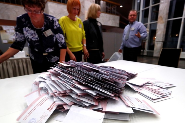 Election officials open ballot box during a general election in Riga