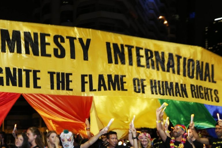 Participants at the 2014 Sydney Gay and Lesbian Mardi Gras march with a human rights banner for Amnesty International, March 1, 2014. REUTERS/Jason Reed