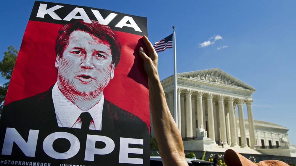 Demonstrators protest against Supreme Court nominee Brett Kavanaugh, as they rally outside of the Supreme Court [File: Jose Luis Magana/AP Photo]