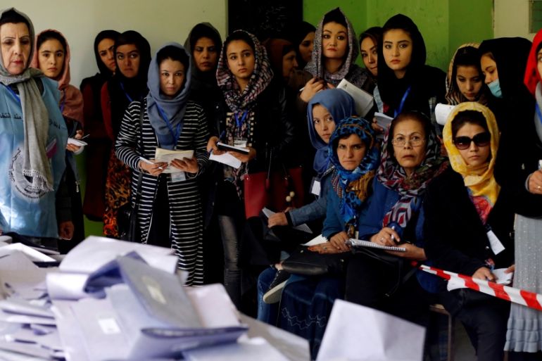 Election observers watch the counting of ballots during parliamentary elections at a polling station in Kabul