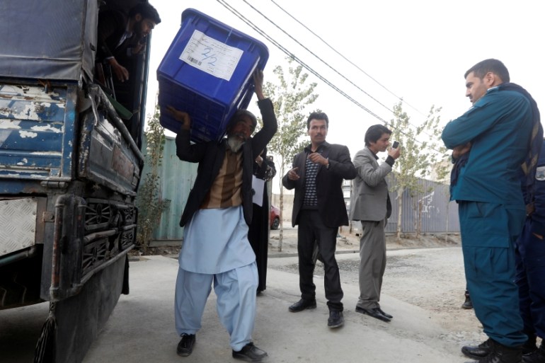 Afghan election commission unloads a ballot box with election material outside a polling station in Kabul