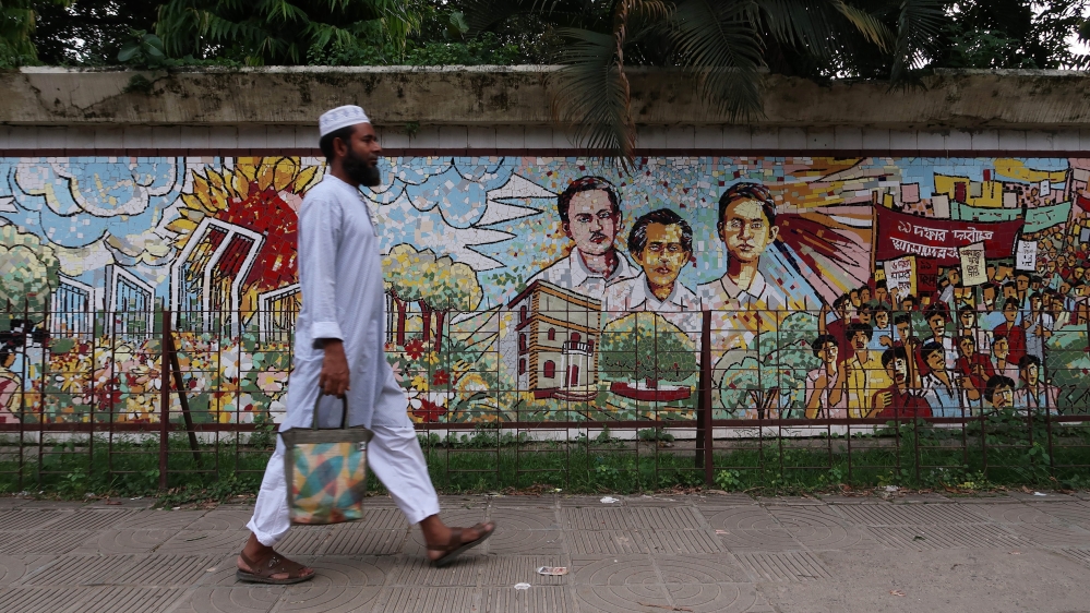 
A man walks past a mosaic in Dhaka depicting the liberation war [Jenny Gustafsson/Al Jazeera]
