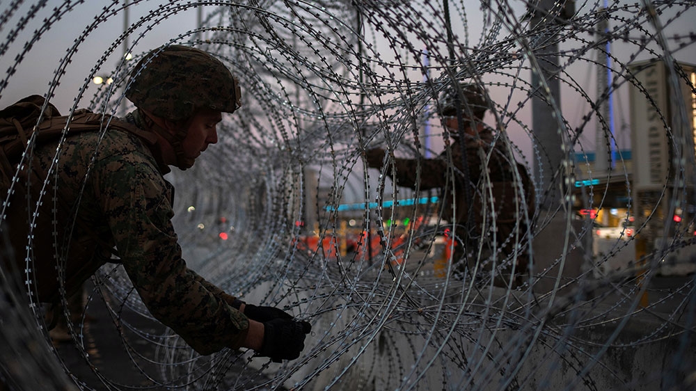 United States Marines fortify concertina wire along the San Ysidro Port of Entry border crossing as seen from Tijuana [Adrees Latif/Reuters] 